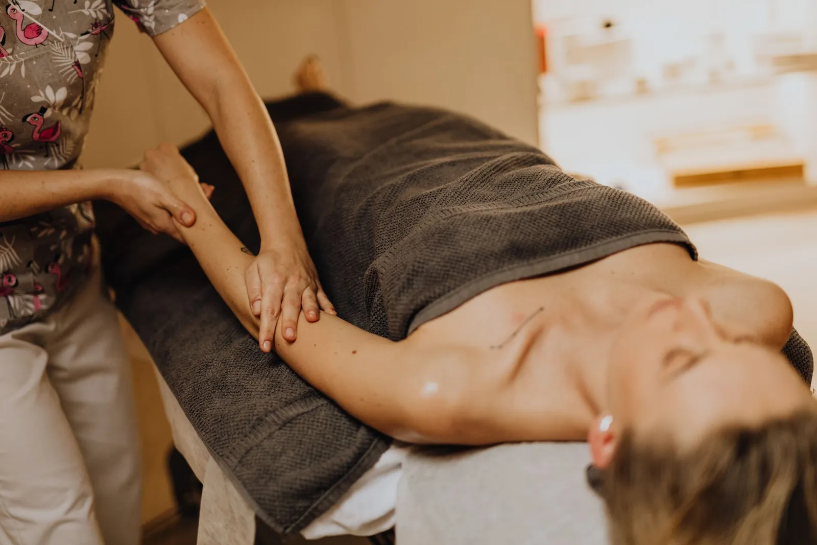 Etirement du bras lors d'un massage, geste enveloppant proche de la technique du lomi-lomi