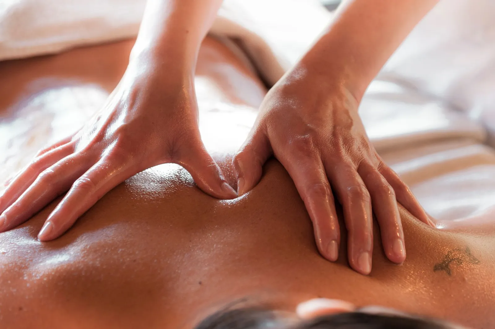 Geste de massage du dos travaillé en formation spa, pression contrôlée sur les lombaires