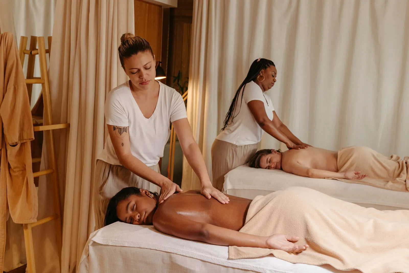 Stagiaires s'exerçant en binôme dans une cabine de pratique durant une formation spa